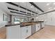 Spacious island in an open kitchen with dark veined granite countertops, stainless steel appliances and hardwood floors at 10084 Terrastone Dr, Las Vegas, NV 89148