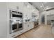 A bright, modern kitchen features stainless steel appliances and sleek, white cabinetry and granite countertops at 10084 Terrastone Dr, Las Vegas, NV 89148