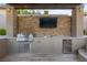 Outdoor kitchen with stainless steel appliances and beautiful stone backsplash at 10084 Terrastone Dr, Las Vegas, NV 89148