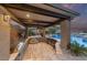 Covered outdoor kitchen with built-in grill, bar seating, and access to the pool and entertainment area at 10084 Terrastone Dr, Las Vegas, NV 89148