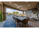 A covered patio features comfortable seating, a fireplace, an outdoor dining area, and a beautiful pool view at 10084 Terrastone Dr, Las Vegas, NV 89148