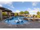 A luxurious swimming pool offers a waterfall feature, lush landscaping, and a relaxing outdoor lounge area at 10084 Terrastone Dr, Las Vegas, NV 89148