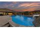 Stunning pool with a rock waterfall, surrounded by desert landscaping and a backdrop of scenic mountains at 10084 Terrastone Dr, Las Vegas, NV 89148