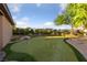 Backyard putting green with artificial turf, mature landscaping, and privacy fencing at 10084 Terrastone Dr, Las Vegas, NV 89148