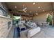 Covered outdoor living space with ceiling fans, dining table, and a clear view to the kitchen at 10084 Terrastone Dr, Las Vegas, NV 89148