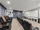 Home theater room featuring tiered seating, a large projection screen, and a modern entertainment center at 10084 Terrastone Dr, Las Vegas, NV 89148