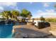 Backyard pool oasis with a rock waterfall, cozy fire pit, and comfortable lounge seating at 10084 Terrastone Dr, Las Vegas, NV 89148