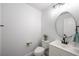 Modern powder room featuring a white vanity, round mirror, and neutral decor at 10244 Amber Hue Ln, Las Vegas, NV 89144