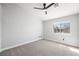 Clean and bright bedroom with a ceiling fan, carpeted floor, and view to the exterior at 10244 Amber Hue Ln, Las Vegas, NV 89144