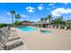 Community pool with lounge chairs, palm trees, and clear blue water on a sunny day at 10244 Amber Hue Ln, Las Vegas, NV 89144