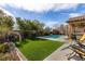 Lush backyard with artificial turf, a sparkling pool, and comfortable lounge chairs at 10417 Artful Stone Ave, Las Vegas, NV 89149