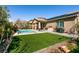 Beautiful backyard with artificial turf, a built-in grill, and a sparkling pool at 10417 Artful Stone Ave, Las Vegas, NV 89149