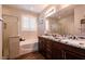 Bathroom featuring double sinks, granite countertop and shower at 10417 Artful Stone Ave, Las Vegas, NV 89149