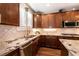 Kitchen showcasing dark wood cabinets, granite countertops, stainless steel appliances, and tile backsplash at 10417 Artful Stone Ave, Las Vegas, NV 89149