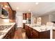Modern kitchen boasts granite countertops, stainless appliances, a large island, and dark wood cabinets at 10417 Artful Stone Ave, Las Vegas, NV 89149