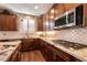 Updated kitchen featuring granite countertops, stainless steel appliances, and dark wood cabinets, perfect for cooking at 10417 Artful Stone Ave, Las Vegas, NV 89149