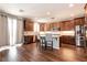 Well-appointed kitchen with stainless steel appliances, kitchen island with seating, and hardwood floors at 10417 Artful Stone Ave, Las Vegas, NV 89149