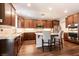 Modern kitchen features stainless appliances, granite counters, dark wood cabinetry, island with seating, and hardwood floors at 10417 Artful Stone Ave, Las Vegas, NV 89149