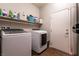 Functional laundry room with a shelf and washer and dryer at 10417 Artful Stone Ave, Las Vegas, NV 89149