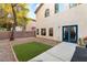The backyard features artificial grass, a concrete patio, and a stucco two-story home at 10754 Balmoral St, Las Vegas, NV 89141