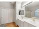 Bright bathroom featuring double sinks, wood floor, and a tiled shower with glass door at 10754 Balmoral St, Las Vegas, NV 89141