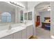 Bathroom featuring double sinks, an arched window, and an ensuite bedroom at 10754 Balmoral St, Las Vegas, NV 89141