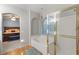 Bathroom featuring a glass door shower, large tub, and an arched window at 10754 Balmoral St, Las Vegas, NV 89141