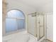 Bathroom featuring a glass shower, large tub, and an arched window at 10754 Balmoral St, Las Vegas, NV 89141