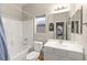 Bright bathroom with white tiles, a shower-tub combo, and updated vanity and sink at 10754 Balmoral St, Las Vegas, NV 89141