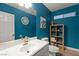 Stylish blue powder room featuring a modern sink, stylish mirror and natural-tone shelving at 10754 Balmoral St, Las Vegas, NV 89141
