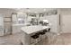 Open-concept kitchen with white cabinets, a center island, and modern stainless steel appliances at 10754 Balmoral St, Las Vegas, NV 89141