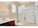This bathroom features a glass-enclosed shower/tub combination, vanity, and a window for natural light at 1158 Gecko Rd, Henderson, NV 89002