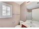 This bathroom has a framed mirror, vanity with sink, toilet, window and a shower/tub combo with tile surround at 1158 Gecko Rd, Henderson, NV 89002