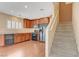 Kitchen with brown cabinets, stainless steel appliances, and stairs leading to the upper level at 1158 Gecko Rd, Henderson, NV 89002