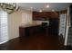 Kitchen with hardwood floors, dark cabinetry, and black appliances at 1158 Gecko Rd, Henderson, NV 89002