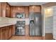 Kitchen featuring brown cabinets, stainless steel appliances, and tile floors at 1158 Gecko Rd, Henderson, NV 89002