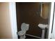 Powder room with pedestal sink and round mirror at 1158 Gecko Rd, Henderson, NV 89002
