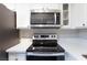Close-up of the stainless steel oven and microwave in the updated kitchen with white cabinets at 1201 Sulphur Springs Ln # 101, Las Vegas, NV 89128