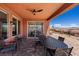 Back patio includes ceiling fan, and dining set, with desert landscaping in backyard at 1424 Pin Cushion Rdg, Mesquite, NV 89034
