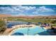 A stunning community pool features desert views, lounge seating, and multiple umbrellas at 1424 Pin Cushion Rdg, Mesquite, NV 89034