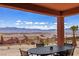 Enjoy mountain views from this covered patio with wrought iron table and chairs for outdoor dining at 1424 Pin Cushion Rdg, Mesquite, NV 89034