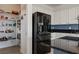 Pantry beside modern kitchen with stainless steel appliances and ample storage and black refrigerator at 1424 Pin Cushion Rdg, Mesquite, NV 89034