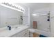 Bright bathroom featuring a vanity, framed mirror, and a shower-tub combo with sliding glass doors at 1509 Linnbaker Ln # 203, Las Vegas, NV 89110