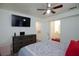 Bright bedroom featuring a ceiling fan, mounted TV, neutral walls, and colorful, patterned rug at 1509 Linnbaker Ln # 203, Las Vegas, NV 89110