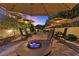 Inviting backyard patio with comfortable seating around a fire pit and lighted shade structures at 17 Grand Corniche Dr, Henderson, NV 89011