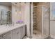 Stylish bathroom featuring a walk-in shower with decorative tile accents and a vanity with pendant lights at 17 Grand Corniche Dr, Henderson, NV 89011