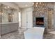 Luxurious bathroom with free-standing tub, fireplace, walk-in shower, and gray double vanity at 17 Grand Corniche Dr, Henderson, NV 89011