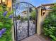 Gated courtyard entrance showcasing a wrought iron gate, lush landscaping, and a water fountain at 17 Grand Corniche Dr, Henderson, NV 89011