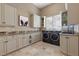 Laundry room featuring built-in cabinets, granite counters, and front-loading washer and dryer at 17 Grand Corniche Dr, Henderson, NV 89011