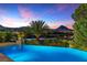 Stunning infinity pool overlooking a serene lake with majestic mountain views at 17 Grand Corniche Dr, Henderson, NV 89011